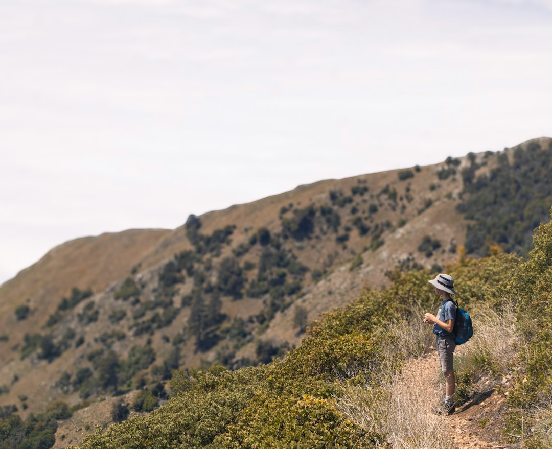 Hiker with backpack standing on a mountain trail