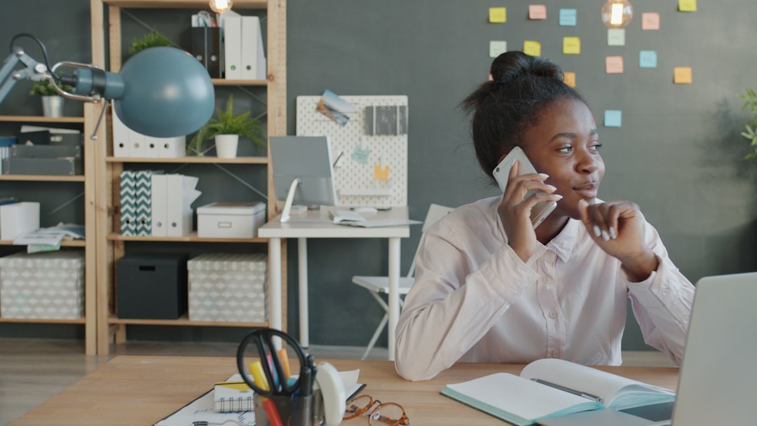 Woman talking on phone at desk in office